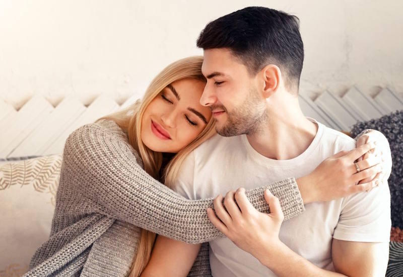 Couple sitting close together and embracing calmly, representing emotional safety, mutual understanding, and clearer communication in a relationship.
